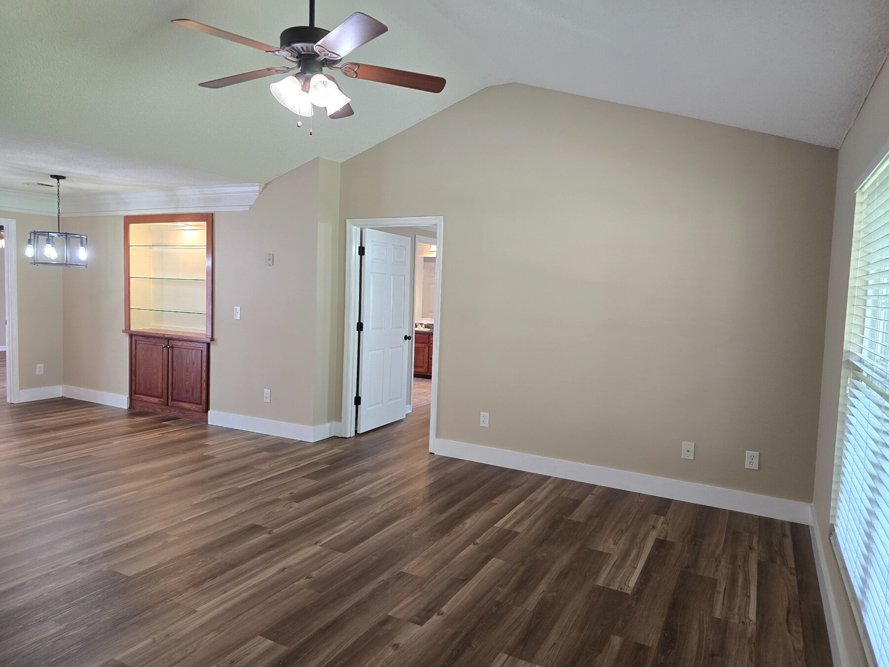 Wide view of the living room with display cabinet and dining area