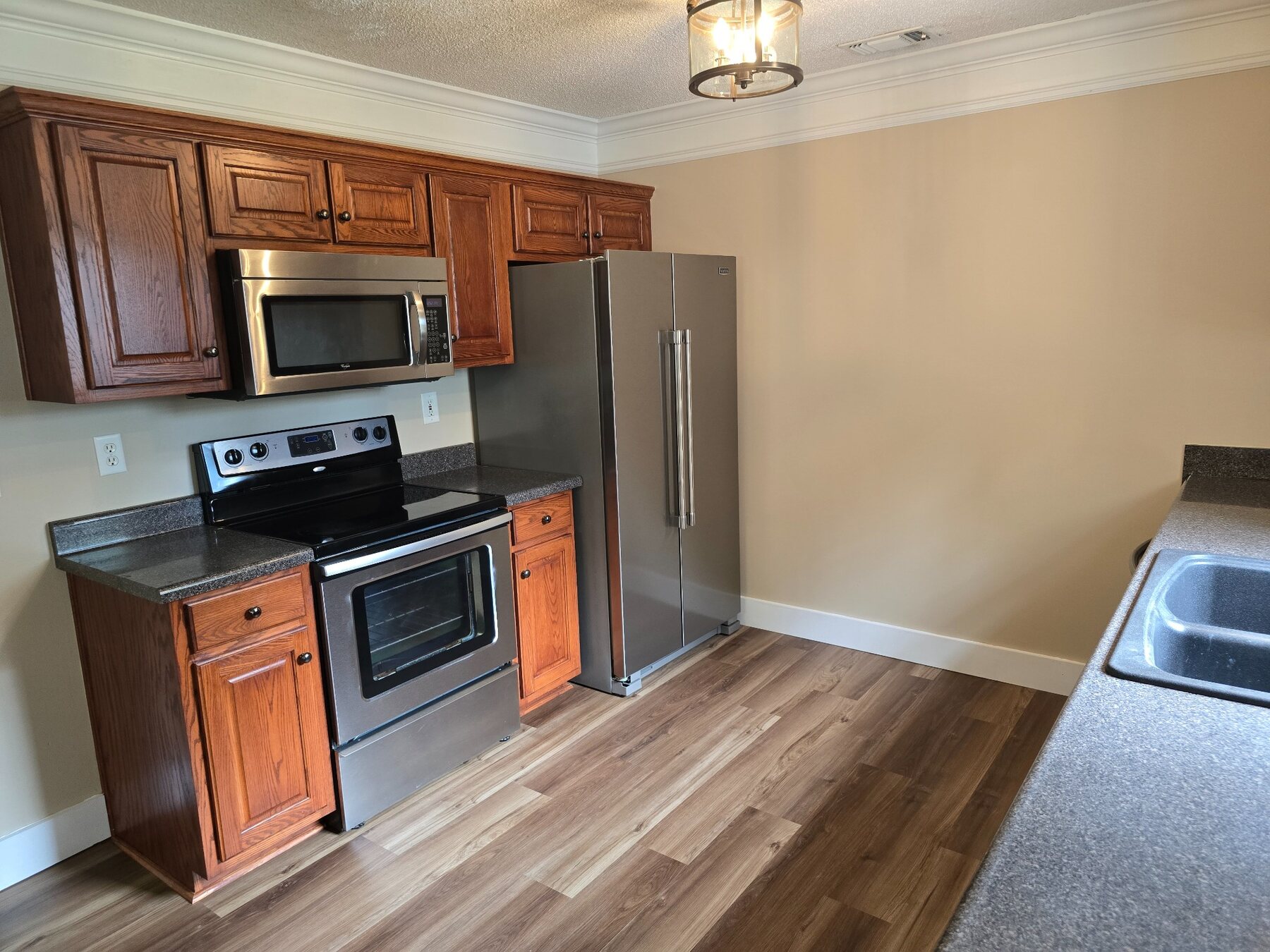 Kitchen cabinetry with stainless-steel range, microwave, and refrigerator