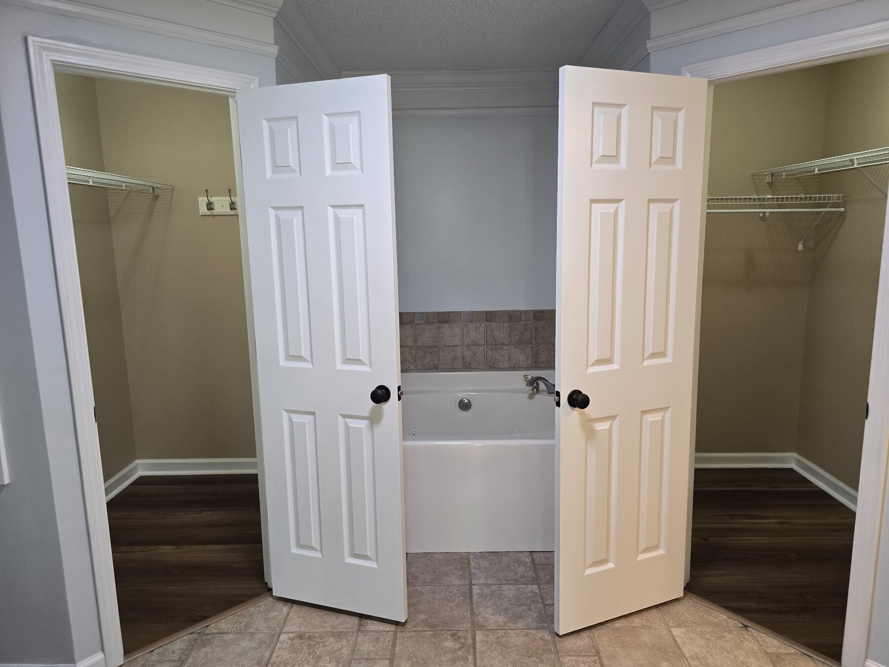 Bathroom suite showing soaking tub and two open closets