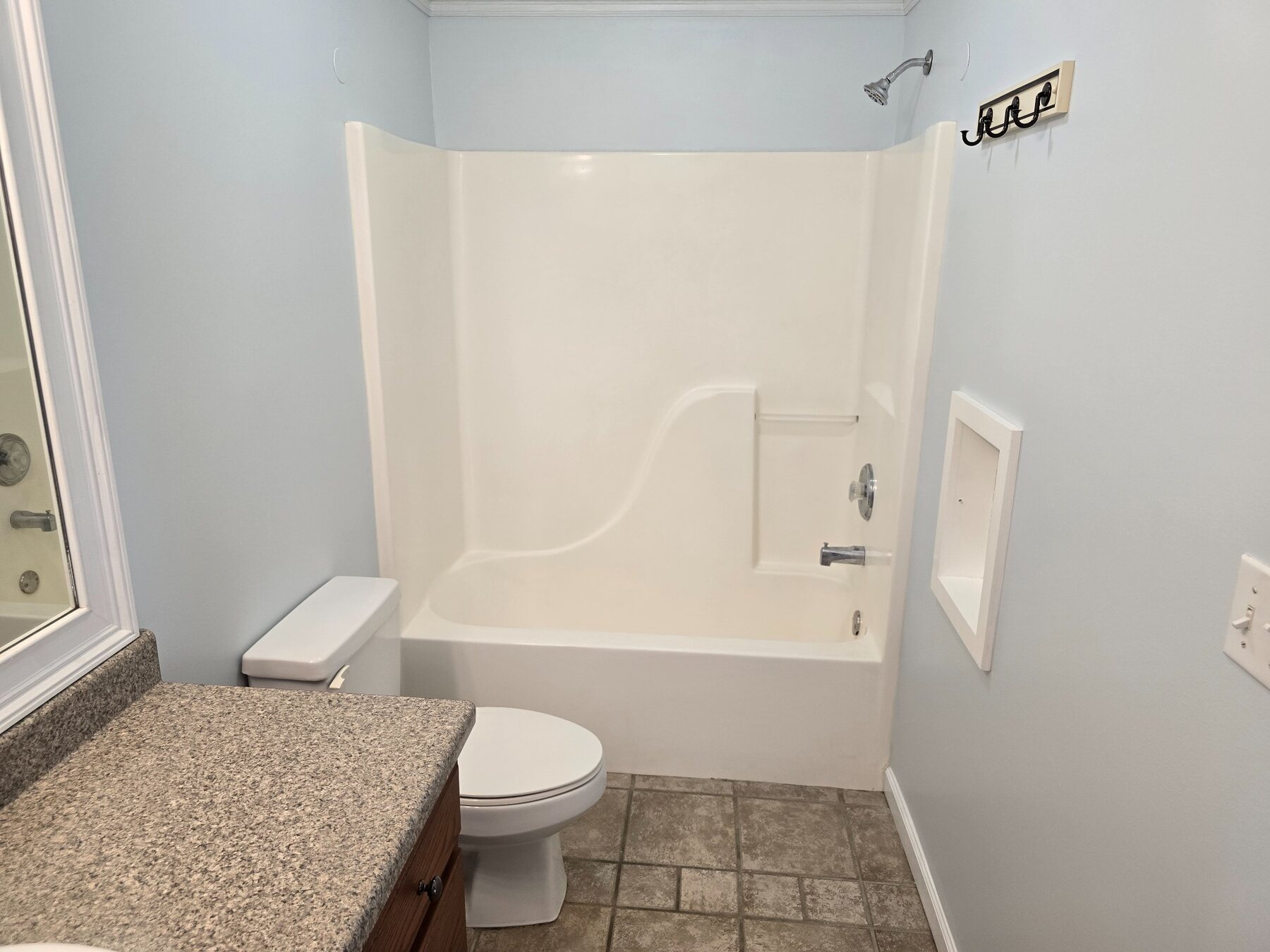 Bathroom with tub and shower combination, toilet, and tiled floor