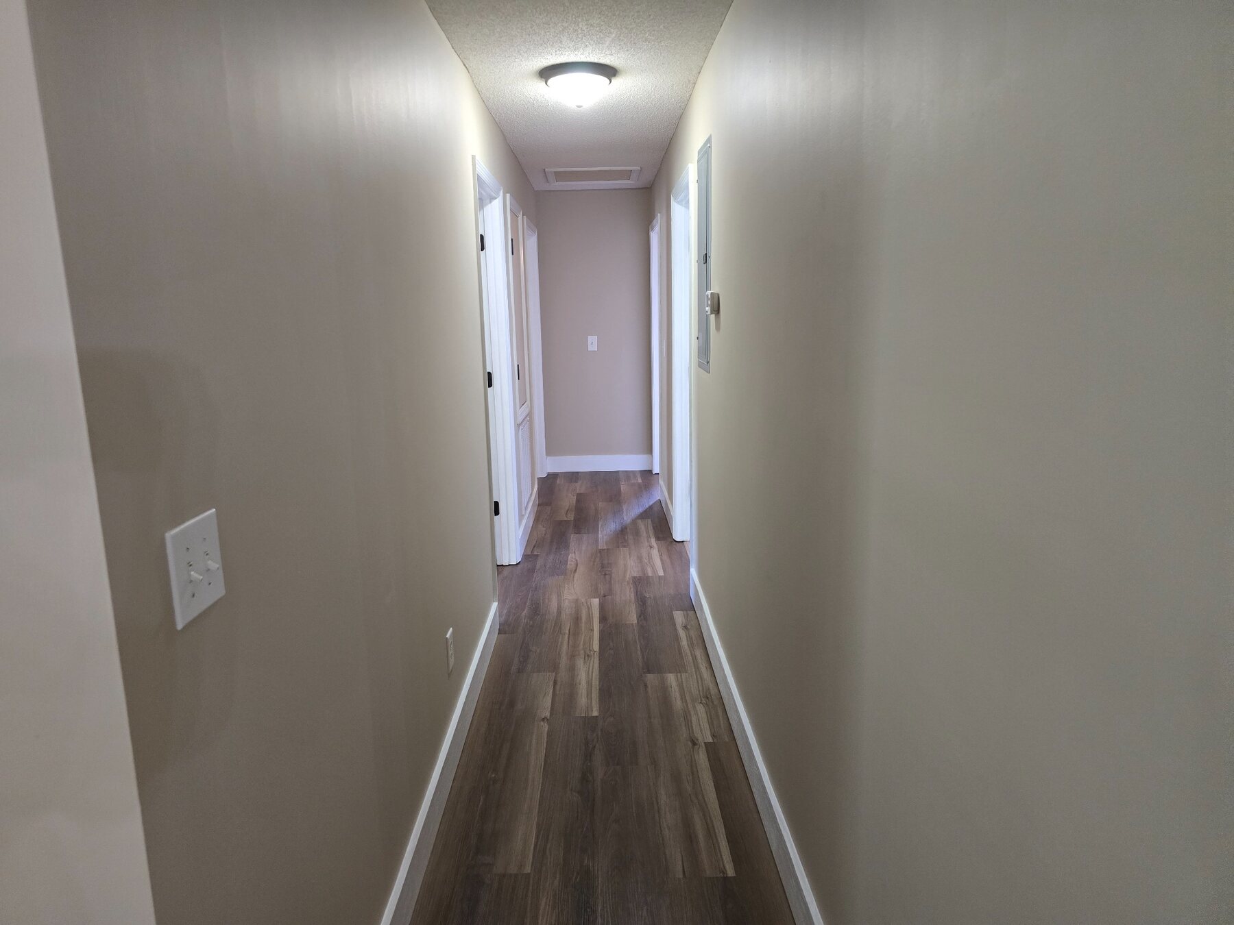 Interior hallway with hard-surface flooring and overhead light