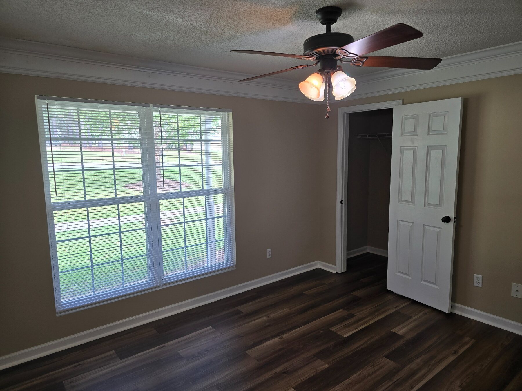 Bedroom with wide window, ceiling fan, and open closet
