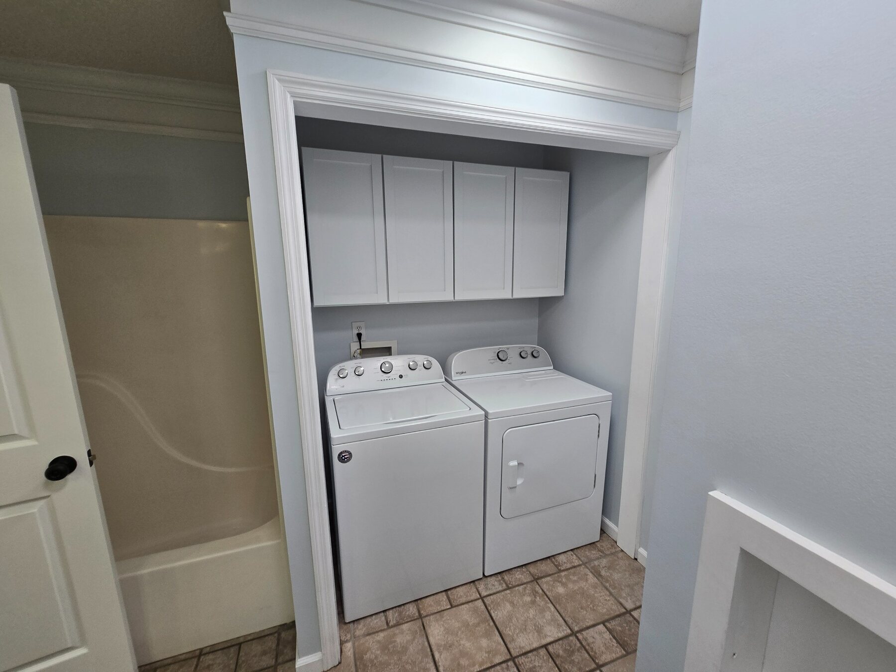 Laundry room with included washer, dryer, wall cabinets, and tiled floor