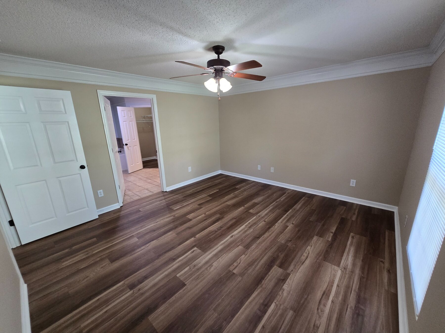 Bedroom with hard-surface flooring, ceiling fan, and crown molding
