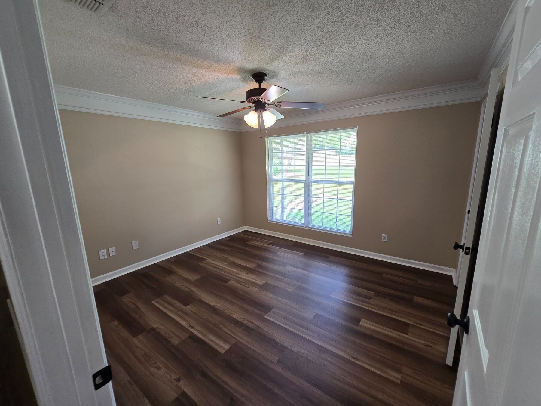 Bedroom with large window, ceiling fan, and crown molding
